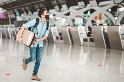 Young man holding suitcase in airport