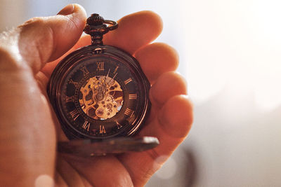 Close-up of hand holding pocket watch