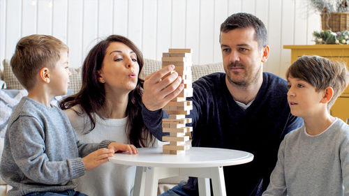 Father and daughter sitting on table