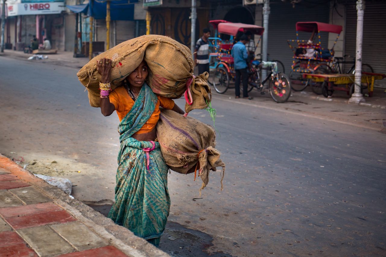 street, full length, lifestyles, bicycle, transportation, land vehicle, road, leisure activity, animal themes, mode of transport, one animal, building exterior, men, city, walking, riding, casual clothing, side view