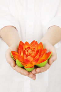 Midsection of woman holding orange flower