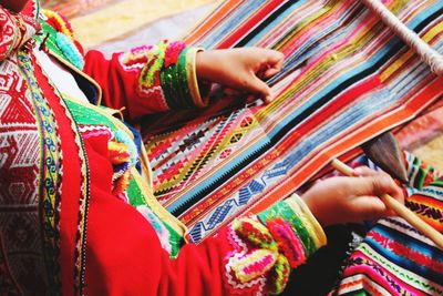 Midsection of woman knitting multi colored threads