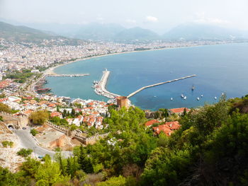 High angle view of townscape by sea against sky