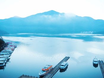 High angle view of sea by mountains against sky