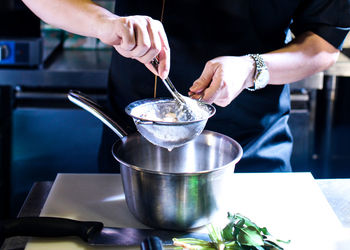 Midsection of man preparing food in kitchen