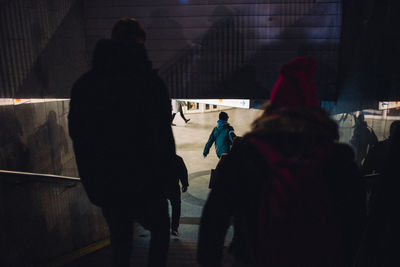 Rear view of people walking in city during winter