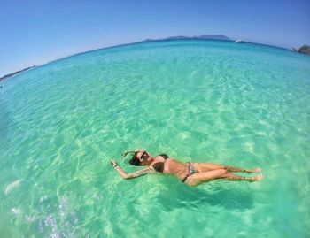 Full length of woman wearing bikini swimming in sea