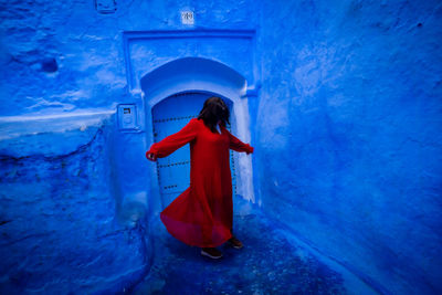 Rear view of woman standing against building