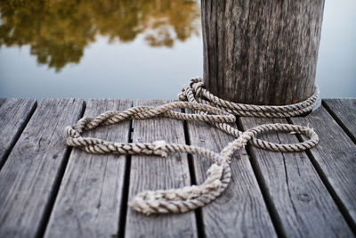 Close-up of rope tied on wooden jetty