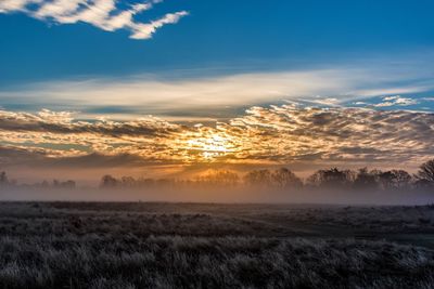 Scenic view of landscape against dramatic sky