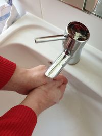 Cropped image of person washing hands in sink