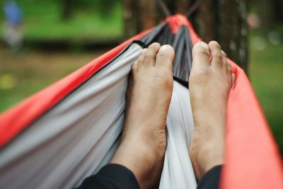 Low section of man relaxing on hammock
