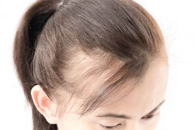 Close-up of woman with hair over white background