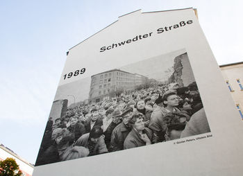 Low angle view of text on building against sky