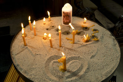 High angle view of lit candles in temple