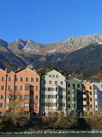 Buildings in city against clear blue sky