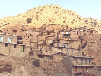 Low angle view of house and mountains against clear sky