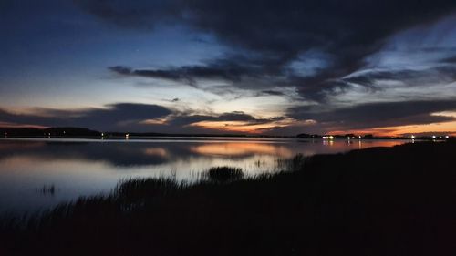 Scenic view of lake against sky at sunset