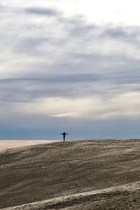 Person standing on beach against sky