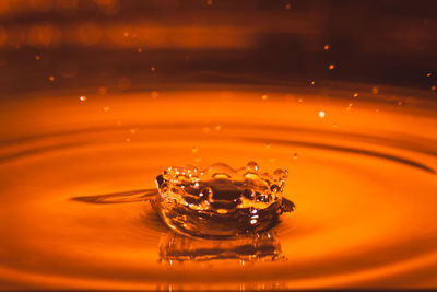 Close-up of water splashing against orange background