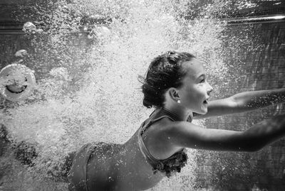 Full length of woman splashing water