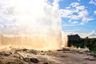 Scenic view of waterfall against sky