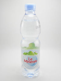 Close-up of glass of bottle against white background