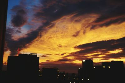 Silhouette of building against cloudy sky