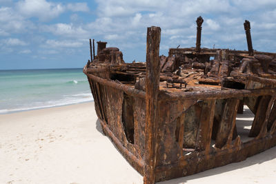 Old ruin on beach against sky