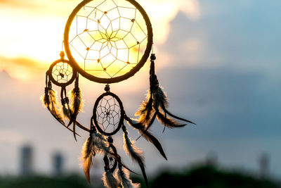 Close-up of feather hanging against sky