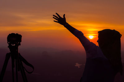 Silhouette of people against sky at sunset