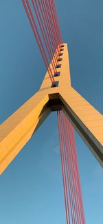 Low angle view of suspension bridge against clear blue sky