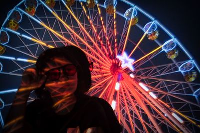 Low angle view of illuminated ferris wheel at night