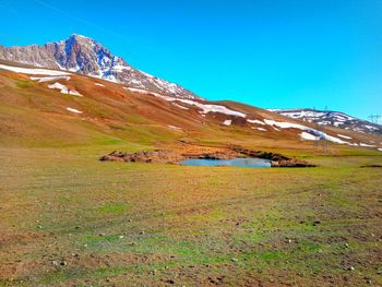 Scenic view of snowcapped mountains against clear blue sky