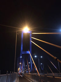 Illuminated bridge against sky at night