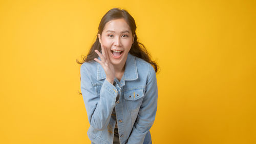 Portrait of smiling man against yellow background