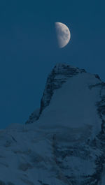 Low angle view of snowcapped mountains against sky at night
