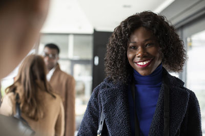 Young businesswoman smiling at receptionist in conference center