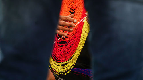 Cropped image of hands holding thread