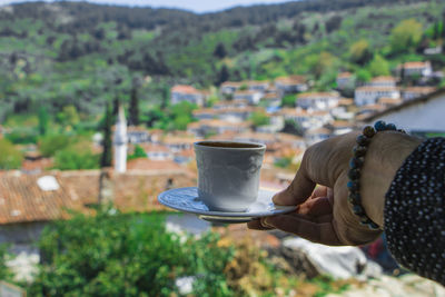 Close-up of hand holding coffee cup