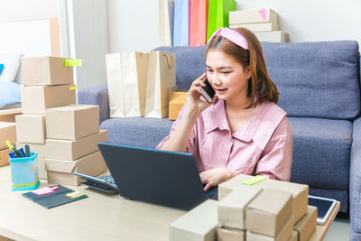 Mid adult woman using mobile phone in box