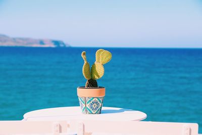 Cross on table against sea