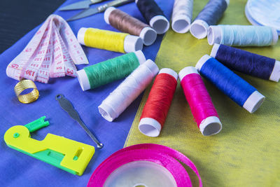 High angle view of colorful sewing items on fabric