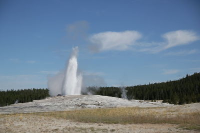 Scenic view of waterfall against sky