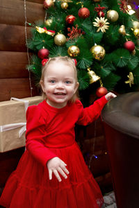 Portrait of cute girl playing with christmas tree