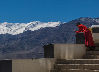 Man standing on snowcapped mountain against sky