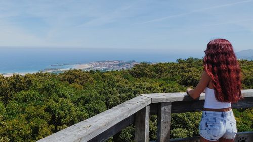 Rear view of woman looking at sea against sky