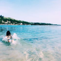Rear view of a woman swimming in sea