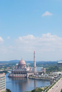 City at waterfront against cloudy sky