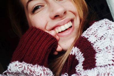 Close-up portrait of cheerful young woman wearing sweater